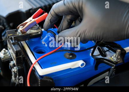 Checking a car battery level with car battery checker, car repairing concept Stock Photo