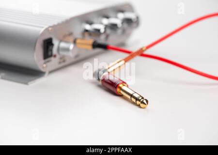 AUX cable connected to mini amplifier. Cable for stereo input and output. Stock Photo