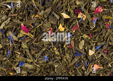 Flavoured green tea with rose petals and exotic fruits - mango, yellow peach and citrus fruits. Stock Photo