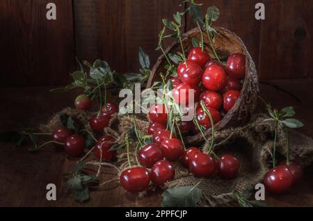 ripe berries of juicy cherries on a dark wooden background Stock Photo