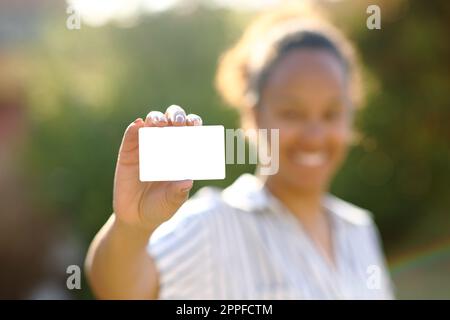 Black woman showing credit card mock up in a park Stock Photo