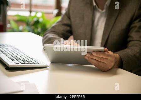 Mid section of a businessman using digital tablet in an office, Bavaria, Germany Stock Photo