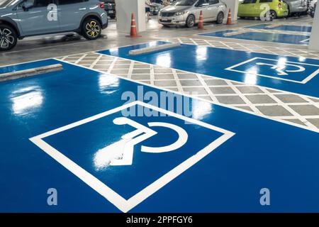 Car parking lot reserved for handicapped driver in supermarket or shopping mall. Car parking space for disabled people. Wheelchair sign paint on parking area. Blue and white handicapped parking lot.