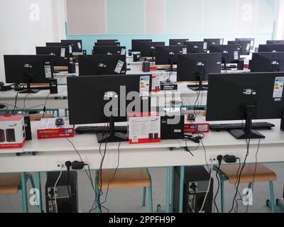 Sremska Mitrovica, Serbia, May 15, 2021 Group of computer neatly placed in a computer lab. Computers, monitors, wires in the modern classroom of the new school. School desks for pupils and students Stock Photo