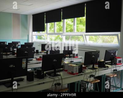 Sremska Mitrovica, Serbia, May 15, 2021 Group of computer neatly placed in a computer lab. Computers, monitors, wires in the modern classroom of the new school. School desks for pupils and students Stock Photo