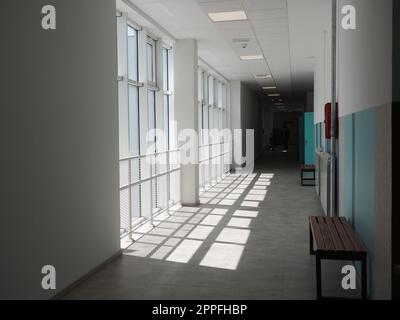 Sremska Mitrovica, Serbia, May 15, 2021. school corridor in a new modern school. White interior of the foyer. High ceilings, large plastic white windows. The sun's rays fall into the room. Stock Photo