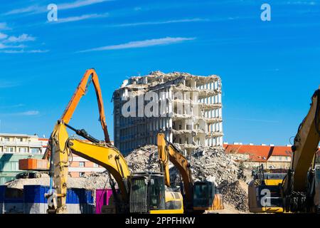 Demolition of the old building with sloopkraan against blue clouds sky. Stock Photo