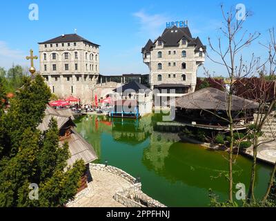 Stanisici, Bijelina, Republika Srpska, Bosnia and Herzegovina April25 2021 Ethno village, tourism and attractions. Stone and wooden buildings of the hotel. People visit restaurant, traditional houses Stock Photo