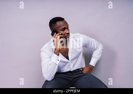 Handsome excited young african business man with mobile phone isolated over gray background Stock Photo