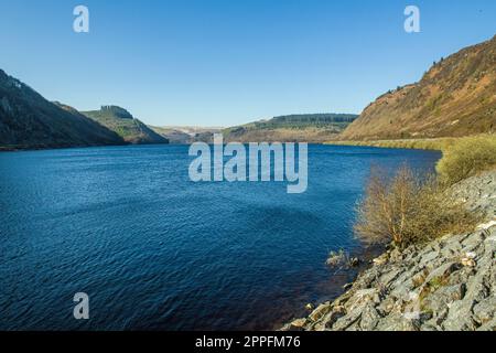 Looking up Caban Coch Reservoir at the start of the Cwm Elan Valley in the County of Powys in Mid Wales on a sunny Spring day in April Stock Photo