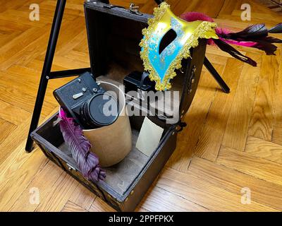 an old SLR camera in a frame and in a chest Stock Photo