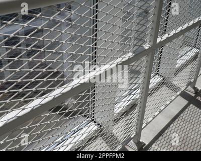 New white frames and windows. Metal fence for the safety of schoolchildren. New modern school. View from the window to the opposite wall and windows. Security systems. Internal office interior. Stock Photo