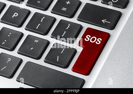 Red button with word SOS on computer keyboard, closeup. Rescue concept Stock Photo
