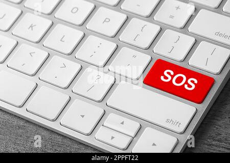 Red button with word SOS on computer keyboard, closeup. Rescue concept Stock Photo