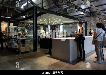 Customers at the famous Lune Croissanterie in Melbourne's Fitzroy queue inside to place an order. In the background, chefs are preparing croissants Stock Photo
