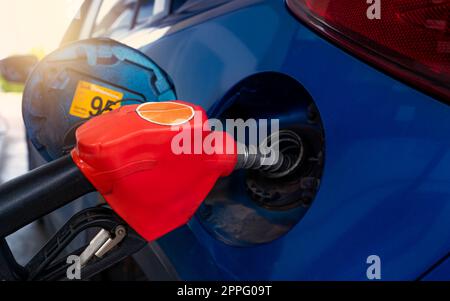 Car fueling at gas station. Refuel fill up with petrol gasoline. Petrol pump filling fuel nozzle in fuel tank of car at gas station. Petrol industry and service. Petrol price and oil crisis concept. Stock Photo