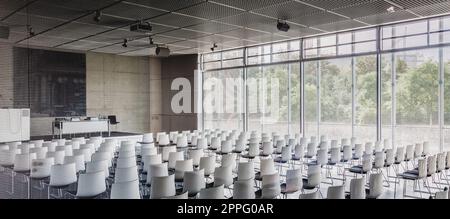 Empty white chairs in contemporary conference hall Stock Photo