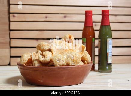 Fried Pork Skins With Hot Sauce in Rustic Kitchen Stock Photo