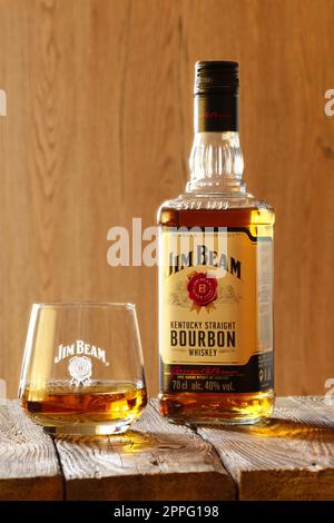 March 28, 2019, Minsk, Belarus - Bottle of kentucky bourbon whiskey with glass on wooden background Stock Photo