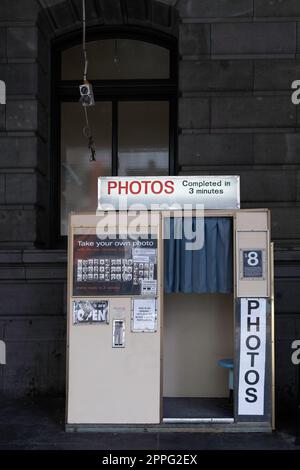 MELBOURNE, AUSTRALIA - MARCH 09 2023: Woman in a vintage photo booth against an old facade at Flinders Street Railway Station, in Melbourne, Australia Stock Photo