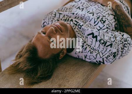 Young happy man lies and looking at the camera, portrait. Stock Photo