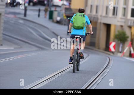 Radfahrer von hinten zwischen StraÃŸenbahnschienen in Gmunden, Ã–sterreich - Cyclists from behind between tram tracks in Gmunden, Austria Stock Photo