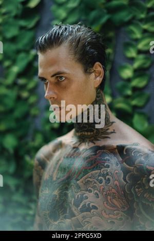 Young handsome man with tattoos in Japanese style. Stock Photo