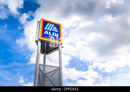 Commercial sign of ALDI Store against a blue sky. ALDI is a large discount supermarket chain in Germany. Stock Photo