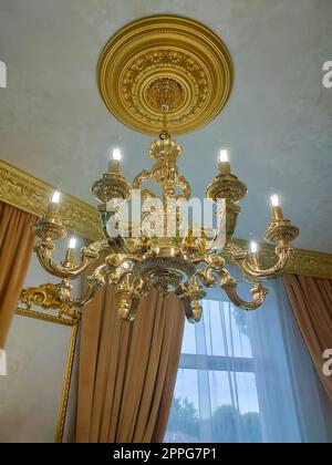 A view from below on a rich chandelier hanging from a ceiling Stock Photo