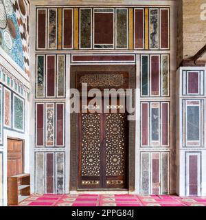 Old colorful marble wall with wooden door decorated with arabesque ornaments, Cairo, Egypt Stock Photo