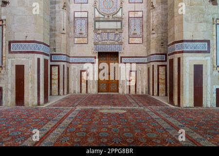 Old decorated stone wall, marble decorations and arabesque decorated wooden door, al Refai Mosque Stock Photo