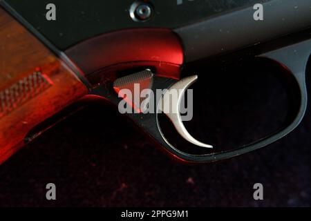 Trigger of a rifle on black background with red lightning Stock Photo