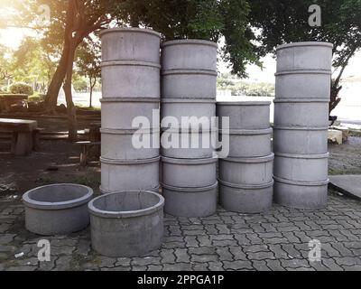 Concrete drainage pipes for industrial building construction stacked at roadside Stock Photo