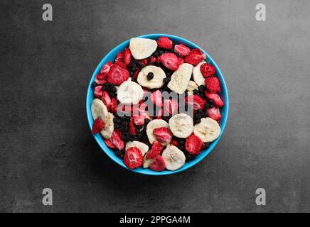 Bowl of dried fruits on grey table, top view Stock Photo