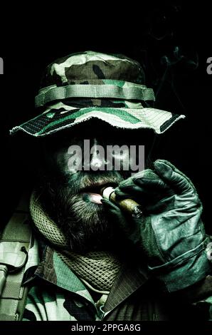 Commando soldier in boonie hat smoking cigar Stock Photo