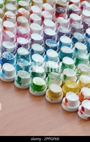 A pattern from a many nozzles from a paint sprayer for drawing graffiti, smeared into different colors. The plastic caps are arranged in many rows forming the color of the rainbow Stock Photo