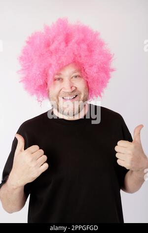 smiling man with pink afro wig Stock Photo