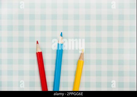 blue red and yellow color pencils on geometric background Stock Photo