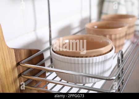 Many different ramekins on metal rack in kitchen, closeup Stock Photo