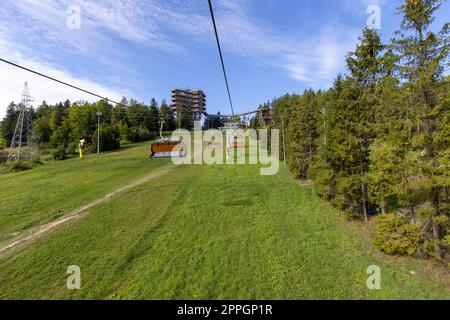 View of chairlift to the mountain with observation tower located at the top of the SÅ‚otwiny Arena ski station, Krynica Zdroj, Beskid Mountains, Slotwiny, Poland. Stock Photo