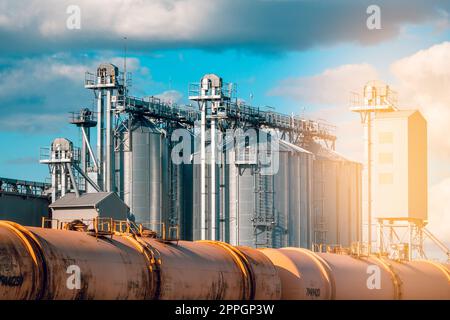 Transportation tank cars standing on the railway next to grain silo Stock Photo