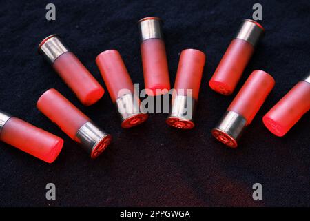 Shotgun shells on a black surface. Ammunition for 12 gauge smoothbore weapons. Hunting ammunition. Dark background. Stock Photo
