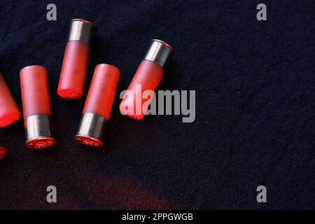 Shotgun shells on a black surface. Ammunition for 12 gauge smoothbore weapons. Hunting ammunition. Dark background. Stock Photo