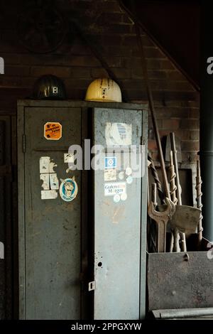 Vertical shot of the miner's helmets on an old locker in a mine in the Ruhr area, Germany Stock Photo