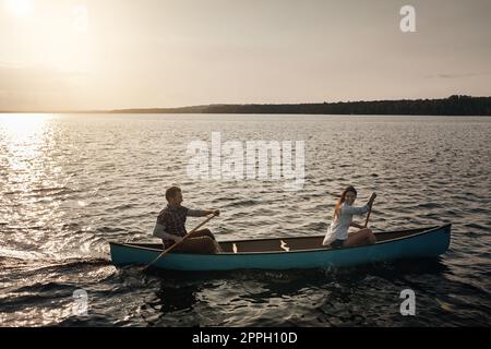 Go where no one is and find peace. a young couple rowing a boat out on the lake. Stock Photo
