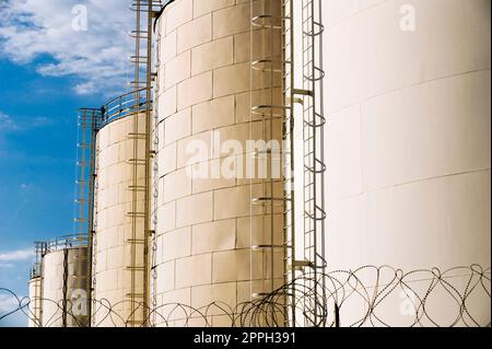 Fuel tanks in a compound secured with barbed wire Stock Photo