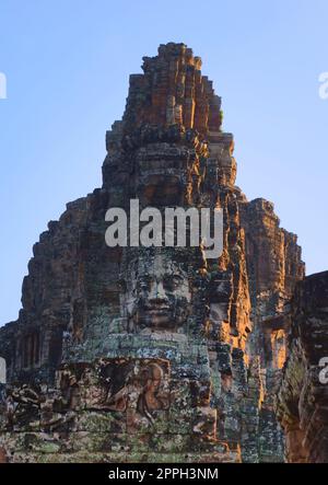 Stone face tower on the Bayon temple, located in Angkor, Cambodia, the ancient capital of the Khmer empire. Stock Photo