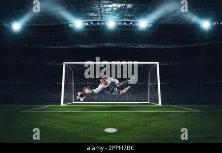 Soccer goalkeeper that makes a great save and avoids a goal during a match at the stadium Stock Photo