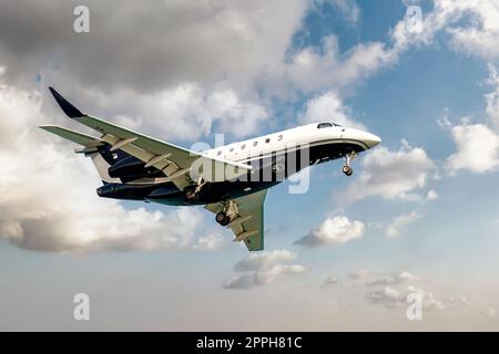 Luxury generic design private jet flying in the cloudy sky Stock Photo