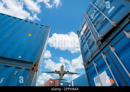Airplane flying above logistic container. Air logistics. Cargo and shipping business. Container ship for import and export logistic. Logistic industry. Container at harbor for truck transport. Stock Photo